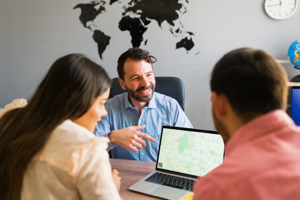 pareja mirando un mapa en una computadora portatil en la agencia de viajes